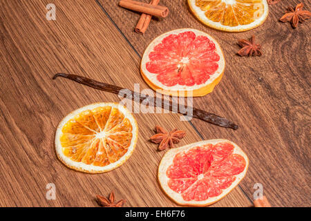 Baccello di vaniglia, tra frutta secca e stella anis. Su sfondo di legno Foto Stock