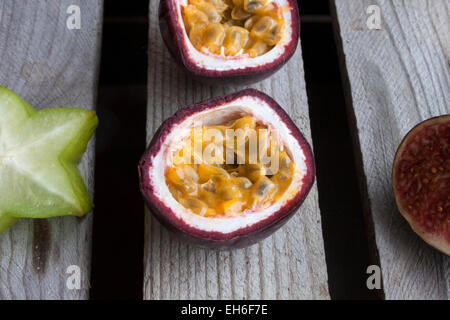 Frutti della passione, carambole vicino, prugna e un altro frutto della passione, sulla massa di legno Foto Stock
