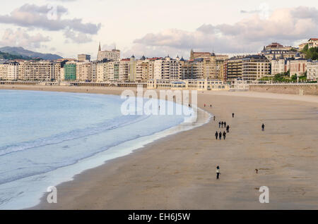 Sunset beach walkers su Playa de la Concha, San Sebastian, Spagna Foto Stock