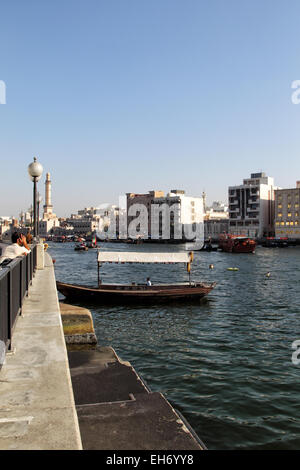 Vista su Dubai Creek dal Deira a Bur Dubai. Abras, tipico traghetti in Dubai, stanno attraversando il fiume; il minareto della G Foto Stock