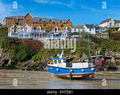 Uomo su una barca da pesca, il porto con la bassa marea, Newquay, Cornwall, England Regno Unito Foto Stock