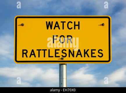 Guardare per rattlesnakes segno con poco nuvoloso cielo blu sullo sfondo Foto Stock