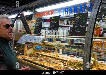 Un uomo studi il menu in un ristorante libanese in Le marché des enfants Rouges Parigi. Foto Stock