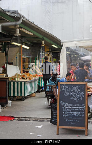 I clienti di mangiare in un organico cafe al marché des enfants Rouges, la più antica restante mercato coperto di Parigi. Foto Stock