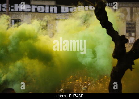 Atene, Grecia. 8 marzo 2015. Panathinaikos fans verde di rilascio il fumo al di fuori dallo stadio. Gli appassionati di calcio greco club Panathinaikos F.C. guardare la partita contro FC PAOK Salonicco al di fuori del stadio vuoto. Tutti i giochi del round corrente della Superleague greca sono riprodotti in stadi vuoti dopo il campionato è stato sospeso dopo i tumulti. Credito: Michael Debets/Alamy Live News Foto Stock