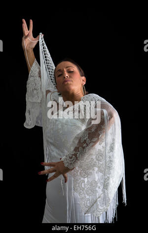 La ballerina di flamenco dorsi con abito bianco e mani incrociate su sfondo nero Foto Stock