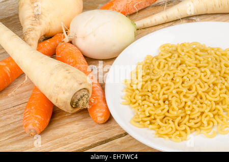 Ingredienti per una zuppa di verdure su una tavola in legno rustico Foto Stock