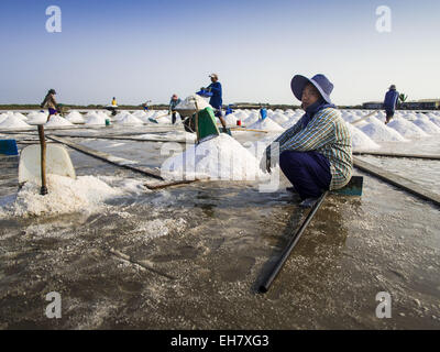 Na Khok, Samut Sakhon, Thailandia. 9 Mar, 2015. Un birmano lavoratore migrante su un sale agriturismo vicino a Samut Sakhon, Thailandia, si prende una pausa durante il raccolto di sale. Le province costiere di Samut Sakhon e Samut Songkhram, a circa 60 miglia da Bangkok, sono al centro della Thailandia del sale di mare industria. Gli agricoltori di sale sale raccolto dalle acque del Golfo del Siam dalle inondazioni dei campi e poi lasciare asciugare attraverso evaporazione, lasciando una crosta di sale dietro. Il sale viene raccolto attraverso la stagione secca, solitamente febbraio ad aprile. Il 2014 sale il raccolto è andato bene nel maggio perché la stagione secca è durato più a lungo della Treuhand Foto Stock