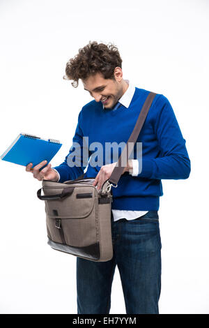 Sorridente giovane uomo in piedi con la borsa per notebook e Foto Stock