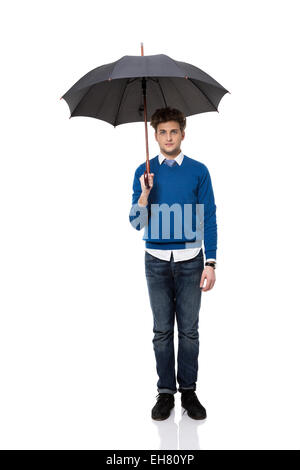 A piena lunghezza Ritratto di un imprenditore in piedi sotto ombrellone Foto Stock