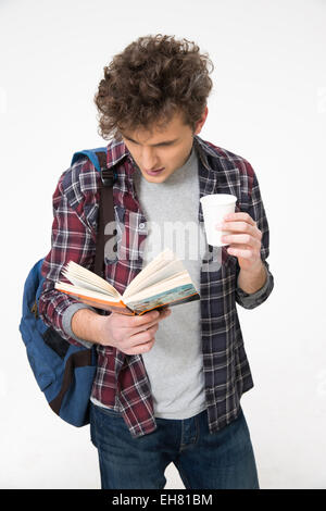 Giovani studenti di sesso maschile in piedi con libro e caffè Foto Stock