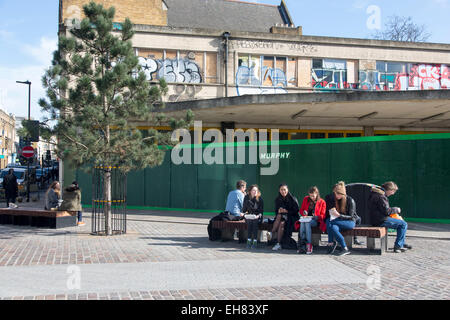 La gente a mangiare cibo da pranzo bancarella vendendo kebab in Shoreditch, Londra, attualmente un posto di giovani hipster creatività. Foto Stock