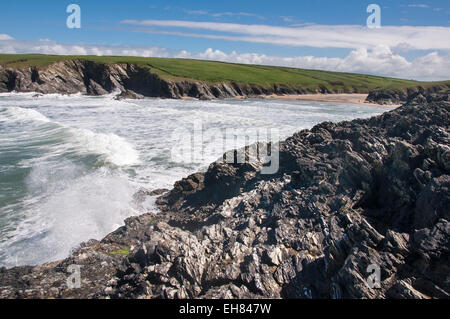 Onde che si infrangono sulle rocce al Porth scherzo vicino a Newquay in Cornovaglia su una soleggiata giornata di primavera. Foto Stock