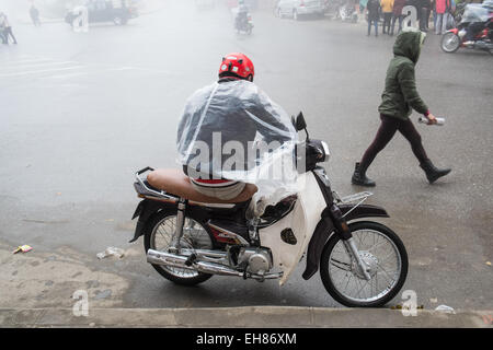 Scooter taxi rider attende una tariffa su un umido e nebbioso giorno in collina città della tribù di Sa Pa,Sapa,Vietnam, Foto Stock