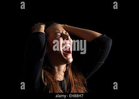 Premuto donna gridando e urlando disperatamente isolato in uno sfondo nero Foto Stock