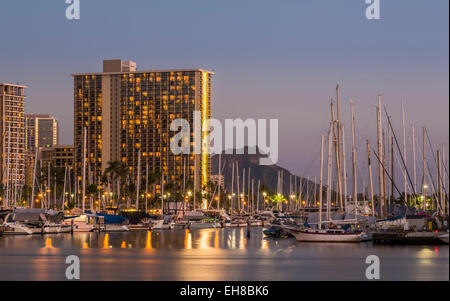 Skyline di Waikiki, Honolulu di notte con Ala Moana Harbour e l'Hilton Hawaiian Village resort hotel Foto Stock