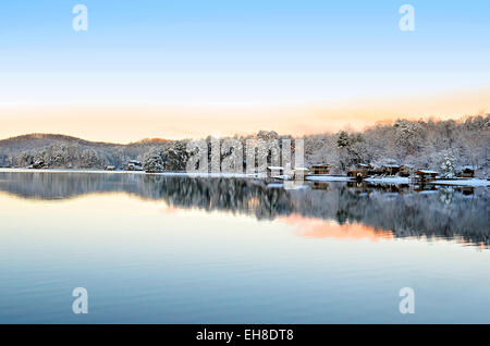 Inverno mattina paesaggio del lago e delle montagne, con riflesso in acqua ed una leggera spolverata di neve. Foto Stock