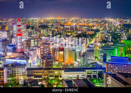 Sendai, Giappone downtown skyline della città guardando verso la stazione principale di notte. Foto Stock