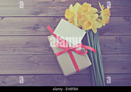 Giunchiglie con confezione regalo con una nota su un tavolo di legno Foto Stock