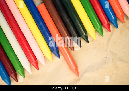 Set di schierate cera colorata pastelli close up su un naturale carta riciclata in background Foto Stock