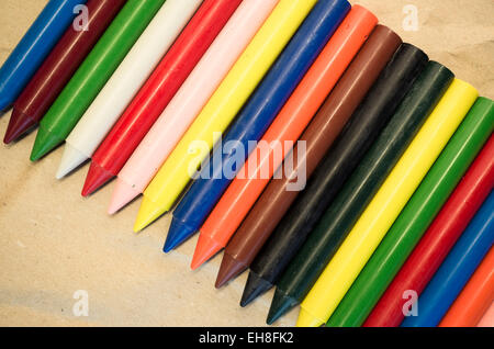 Set di schierate cera colorata pastelli close up su un naturale carta riciclata in background Foto Stock