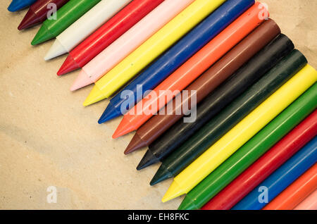 Set di schierate cera colorata pastelli close up su un naturale carta riciclata in background Foto Stock