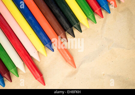 Set di schierate cera colorata pastelli close up su un naturale carta riciclata in background Foto Stock