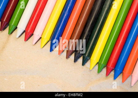 Set di schierate cera colorata pastelli close up su un naturale carta riciclata in background Foto Stock