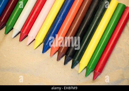 Set di schierate cera colorata pastelli close up su un naturale carta riciclata in background Foto Stock