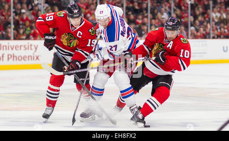 Chicago, IL, Stati Uniti d'America. 08 Mar, 2015. Chicago, Illinois, Stati Uniti - Blackhawks #19 Jonathan Toews e #10 Patrick Sharp battaglia con Ranger #27 Ryan McDonagh durante la National Hockey League tra Chicago Blackhawks e il New York Rangers presso la United Center di Chicago, IL. © csm/Alamy Live News Foto Stock