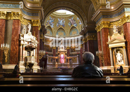 Uomo in preghiera nella Basilica di Santo Stefano (chiesa), Budapest, Ungheria Foto Stock
