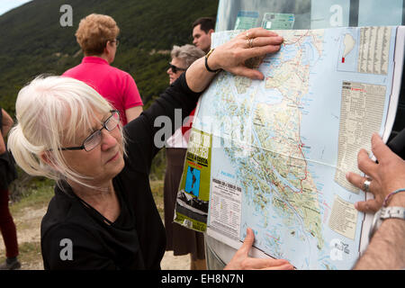 Arg051Argentina, Tierra del Fuego, Ushuaia, senior turista femminile guardando alla posizione sulla mappa Foto Stock