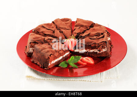 Morbida spugna di cioccolata farcita con crema alla vaniglia e ricoperto di cioccolato fogli Foto Stock