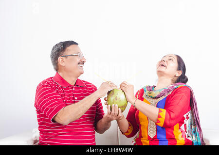 2 Seniors indiano le coppie sposate divano potabile frutti di noce di cocco Foto Stock