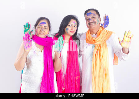 3 indian adulti genitori e figlia Holi festival che mostra a mano Foto Stock