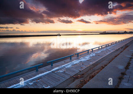 Il sole al tramonto sul lago Ontario a Marilyn Bell Park a Toronto, Ontario, Canada. Foto Stock