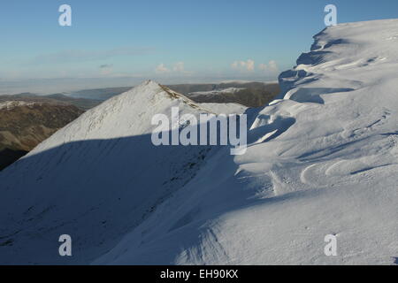Helvellyn inverno, la neve cornicioni drammatiche sculture di neve Swirral Edge e Catstyecam dal vertice Helvellyn, neve su Helvellyn Foto Stock