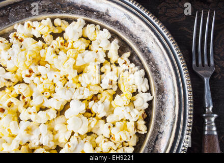 Sana Popcorn imburrato con il sale in una piastra Foto Stock