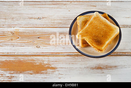 Due fette di pane tostato su sfondo di legno. Messa a fuoco selettiva Foto Stock