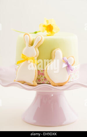 Fondente torta ricoperta con due Easter Bunny cookies di zucchero Foto Stock