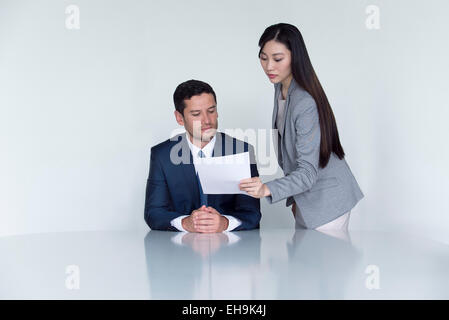 Business Associates guardando il documento in riunione Foto Stock