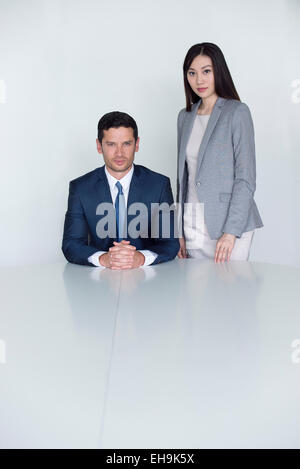 Executive seduto accanto all'assistente permanente, ritratto Foto Stock