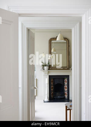 Visualizzare attraverso la porta bianca in camera con camino e specchio, casa residenziale, Porto Hall Street, Brighton East Sussex, Regno Unito Foto Stock