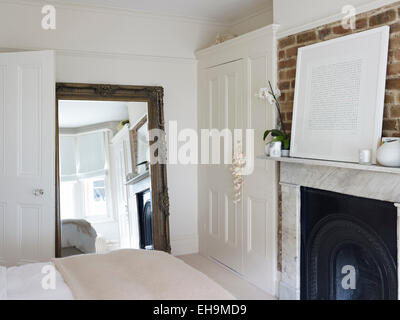 Camera da letto color crema e nero in moderna casa di nuova costruzione, letto  matrimoniale kingsize, sedia, finestra dormer, camera mansardata,  illuminazione comodino, parete a specchio Foto stock - Alamy