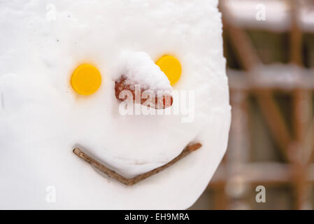 Testa di pupazzo di primo piano con la carota naso pulsante giallo occhi inverno epic copyspace bianco della neve gioiosa gioia invernale Foto Stock