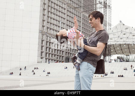 Padre scherzosamente holding baby figlio Foto Stock