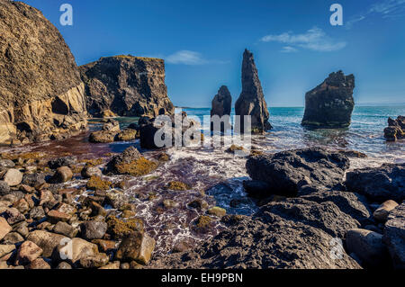 Riva del mare con pietra lavica e pilastri, penisola di Reykjanes, Islanda Foto Stock