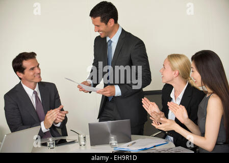 Executive ricevendo applausi dai colleghi durante la presentazione Foto Stock