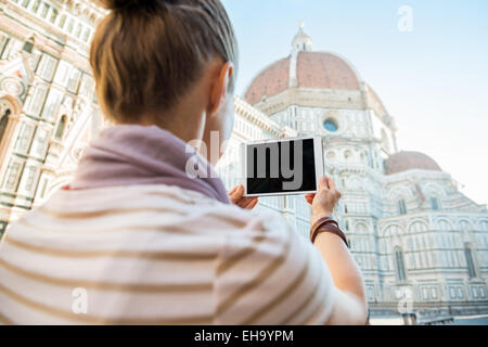 Giovane donna prendendo foto con tablet pc della cattedrale di Santa Maria del Fiore a Firenze. vista posteriore Foto Stock