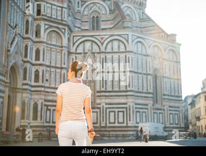 Giovane donna in piedi con la mappa nella parte anteriore della cattedrale di Santa Maria del Fiore a Firenze. vista posteriore Foto Stock